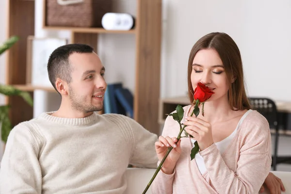 Hermosa mujer joven que recibe la flor de su novio en la cita romántica en casa — Foto de Stock