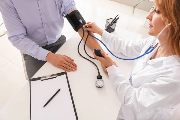 Cardiologista examinando paciente do sexo masculino na clínica — Fotografia de Stock