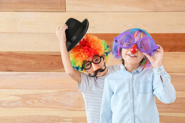 Little children in funny disguise on wooden background. April fools' day celebration — Stock Photo, Image