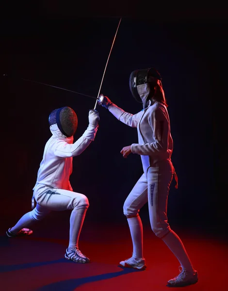 Toned photo of young fencers on dark background — 스톡 사진