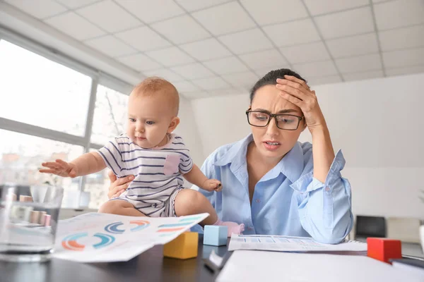 Stressed mother with her baby working in office — Stock Photo, Image