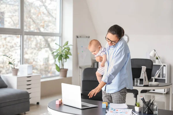 Working mother with her baby in office — Stock Photo, Image