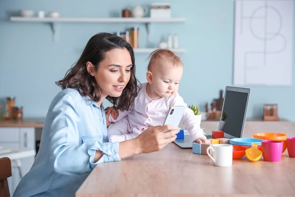 Working mother with her baby at home — Stock Photo, Image