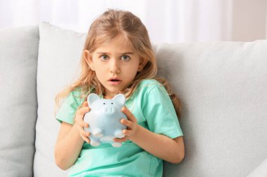 Evinde domuz kumbarası olan korkmuş tatlı kız.