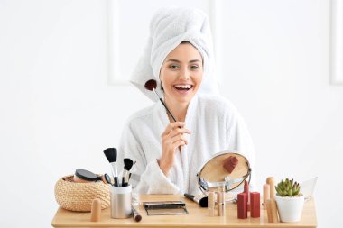 Sabah güzel genç kadının evde makyaj uygulamak