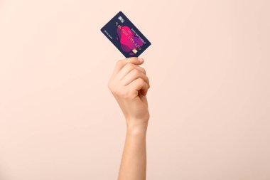 Renk arkaplanında kredi kartı olan bir kadın.