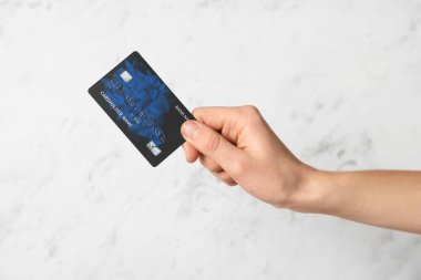 Female hand with credit card on light background