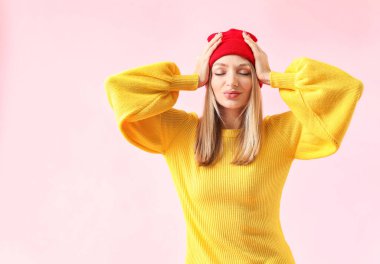 Renkli arka planda kalın kazaklı genç bir kadın.