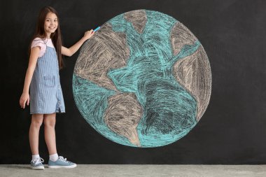 Küçük kız karanlık arka planda gezegen çiziyor. Dünya Günü kutlaması