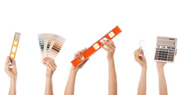 Beyaz arka planda mimarın malzemeleriyle birçok el.