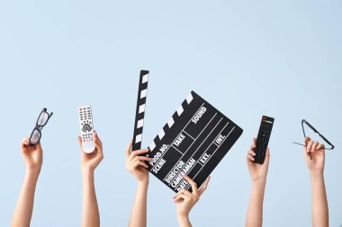 Uzaktan kumandalı bir sürü el, renkli arka planda film alkışı ve gözlük.