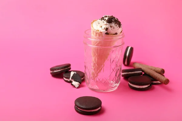 Frasco com saboroso sorvete e biscoitos de chocolate no fundo de cor — Fotografia de Stock
