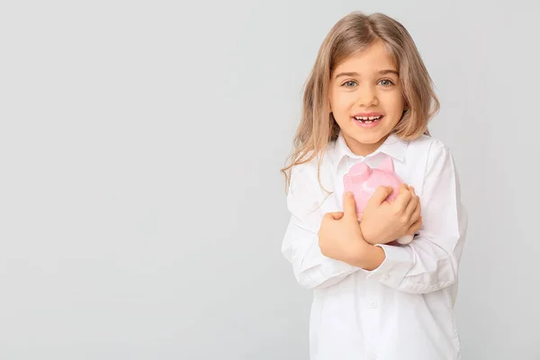 Cute girl with piggy bank on white background — Stock Photo, Image
