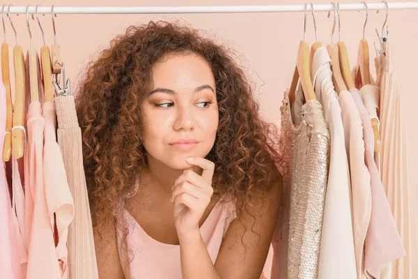 Afroamerikansk stylist nära rack med moderna kläder — Stockfoto