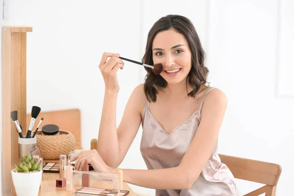 Beautiful young woman applying makeup at home — Stock Photo, Image