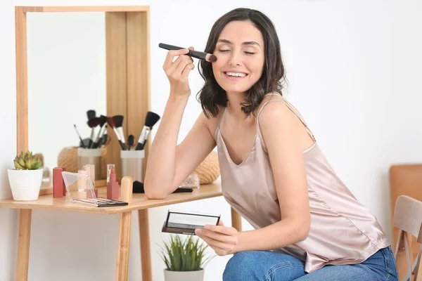 Bela jovem mulher aplicando maquiagem em casa — Fotografia de Stock