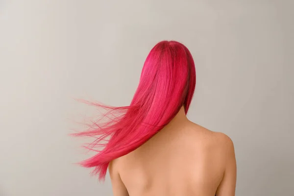 Belle jeune femme avec une couleur de cheveux inhabituelle sur fond clair — Photo