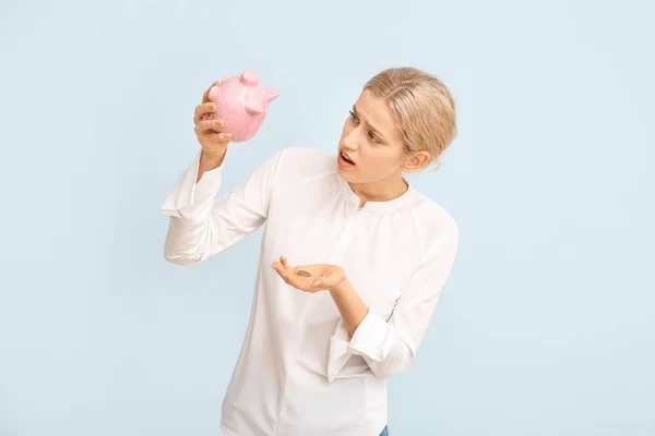 Sad woman with empty piggy bank on color background — Stock Photo, Image