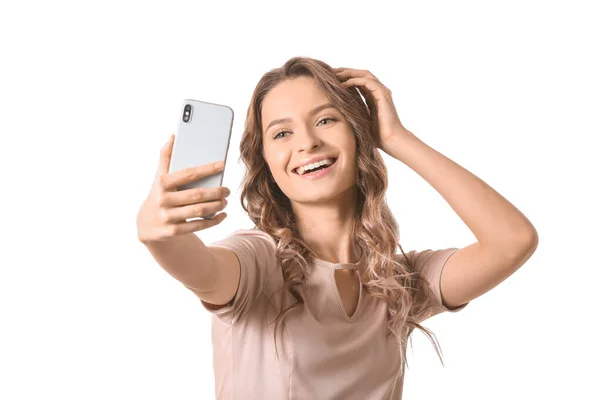 Jonge vrouw het nemen van selfie op witte achtergrond — Stockfoto