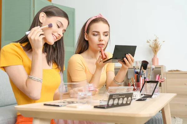 Beautiful young women applying makeup together at home — Stock Photo, Image