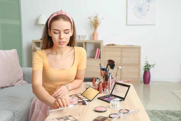 Bela jovem mulher aplicando maquiagem em casa — Fotografia de Stock