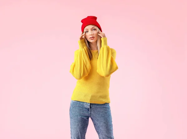 Jeune femme en pull chaud sur fond de couleur — Photo
