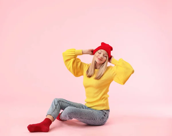 Mujer joven en suéter cálido sobre fondo de color — Foto de Stock