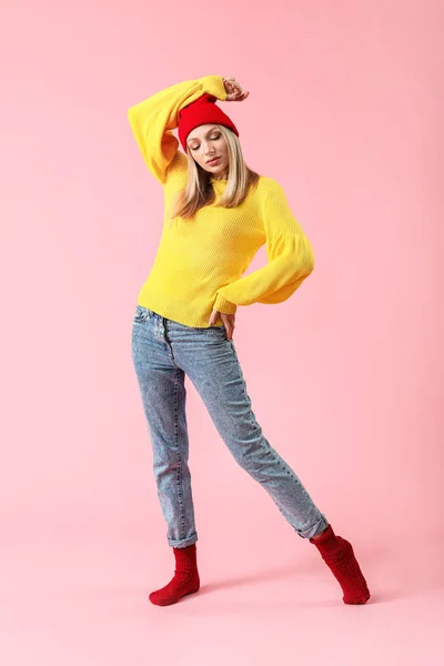 Young woman in warm sweater on color background — Stock Photo, Image