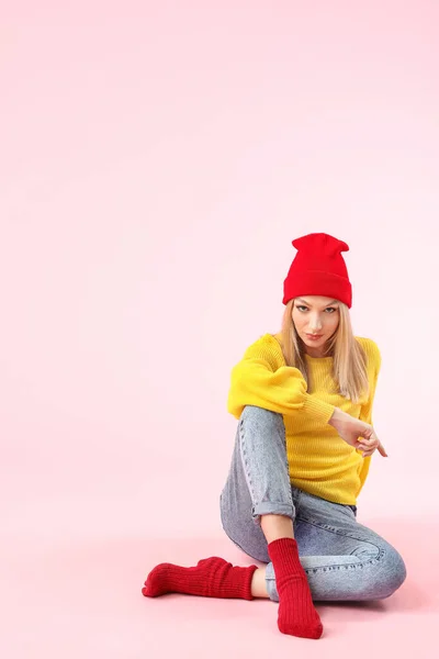 Ung kvinna i varm tröja på färg bakgrund — Stockfoto