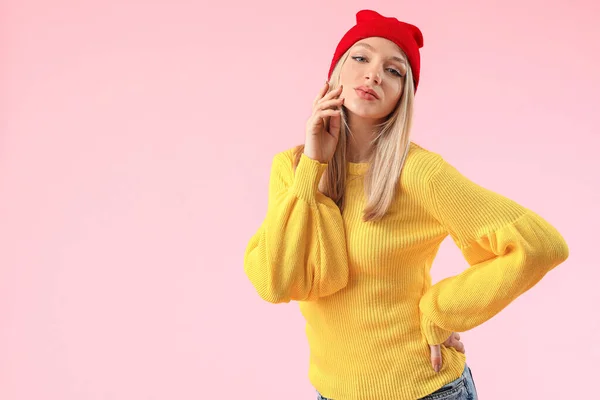 Mladá žena v teplém svetru na barevném pozadí — Stock fotografie