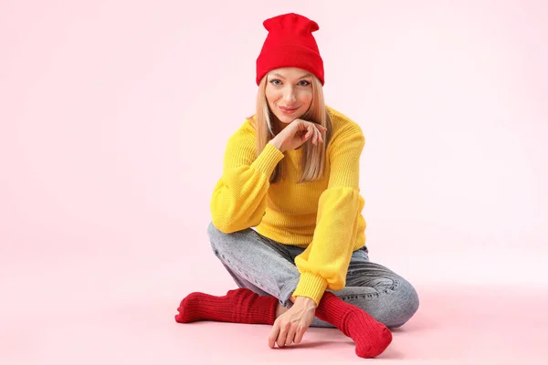 Young woman in warm sweater on color background — 스톡 사진
