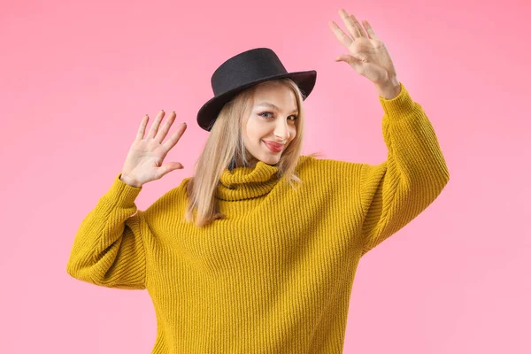 Young woman in warm sweater on color background — Stock Photo, Image