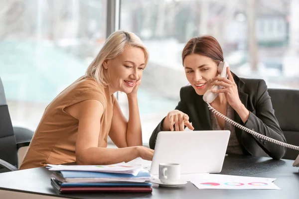 Female accountant and her colleague working in office — Stock Photo, Image
