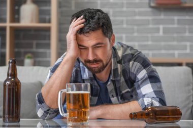 Evde bira içen bir adam. Alkolizm kavramı