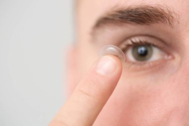 Genç adam kontak lens takıyor, yakın plan.