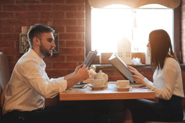 Restoranda oturan menüsü olan genç çift