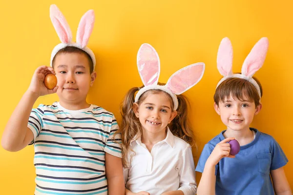 Kleine Kinder Mit Ostereiern Und Hasenohren Auf Farbigem Hintergrund — Stockfoto