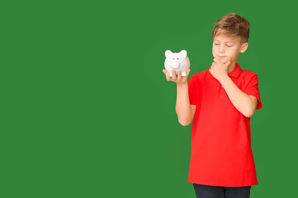 Thoughtful Cute Boy Piggy Bank Color Background — Stock Photo, Image