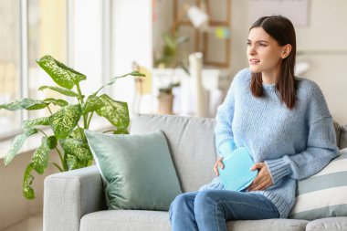 Evde adet sancısı çeken genç bir kadın.