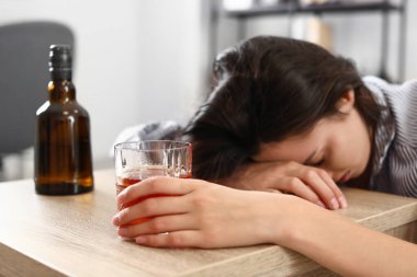 Evde konyak içen bir kadın. Alkolizm kavramı