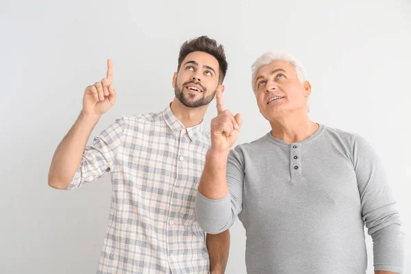 Jongeman Zijn Vader Wijzen Naar Iets Een Lichte Achtergrond — Stockfoto