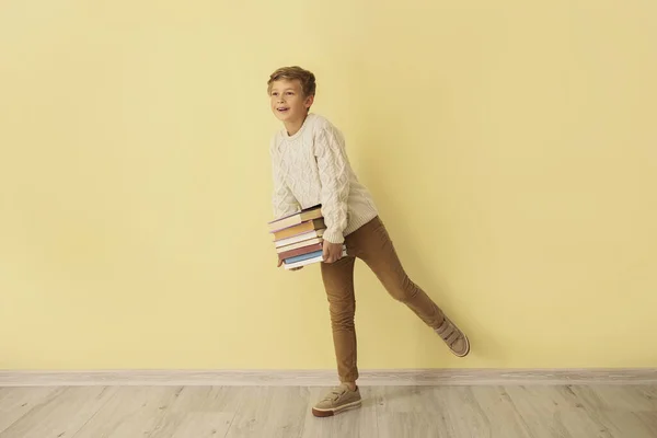 Маленький Мальчик Книгами Возле Цветной Стены — стоковое фото