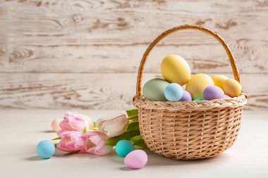 Güzel Paskalya yumurtaları ve çiçeklerle dolu bir sepet.