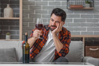 Evde şarap içen bir adam. Alkolizm kavramı