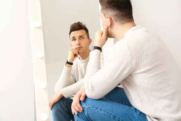 Задумчивый Молодой Человек Смотрит Зеркало Свое Отражение — стоковое фото