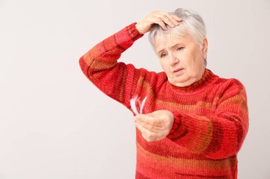 Arka planda saç dökülme sorunu olan son sınıf öğrencisi bir kadın.