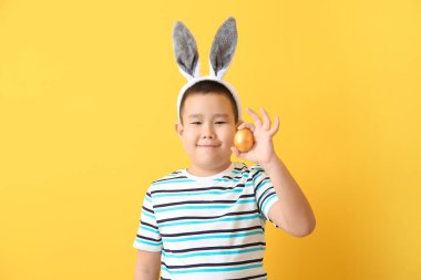 Paskalya yumurtası ve renkli tavşan kulaklı küçük Asyalı çocuk.