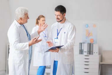 Erkek doktorlar klinikte bir şey tartışıyorlar.