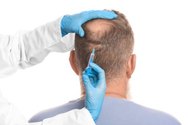 Saç dökülme sorunu olan son sınıf öğrencisi beyaz arka planda iğne yaptırıyor.