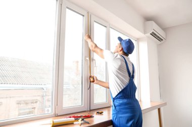 Erkek işçi pencereyi daireye kuruyor